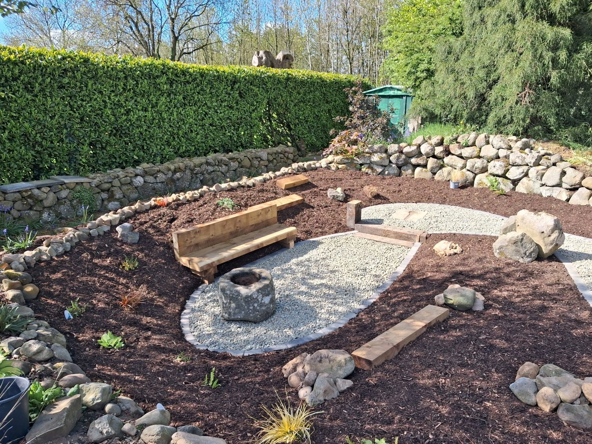 Rockery garden area with wooden bench