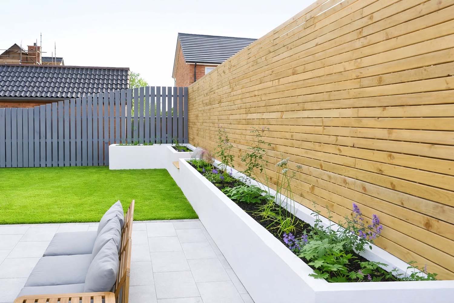 Horizontal wooden panel fence in back garden with planter boxes